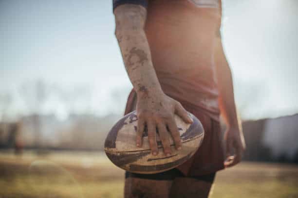 One man holding rugby ball